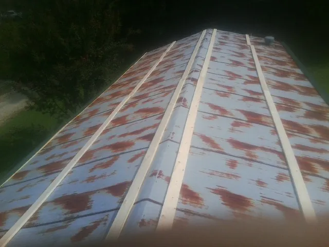 Rusted metal roof panels with new wood purlins before replacement — Storm Damage Roof Repair in Kinzers by Roofing Brothers