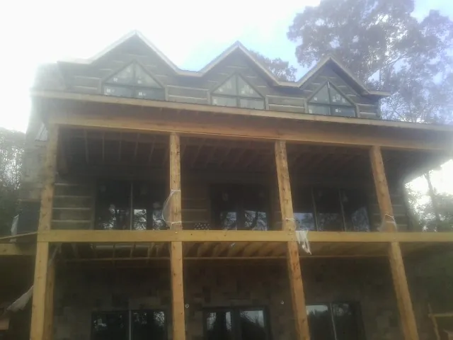 Dormers and porch framing on a large log home under construction — Roof Coating work by our crew in Kinzers